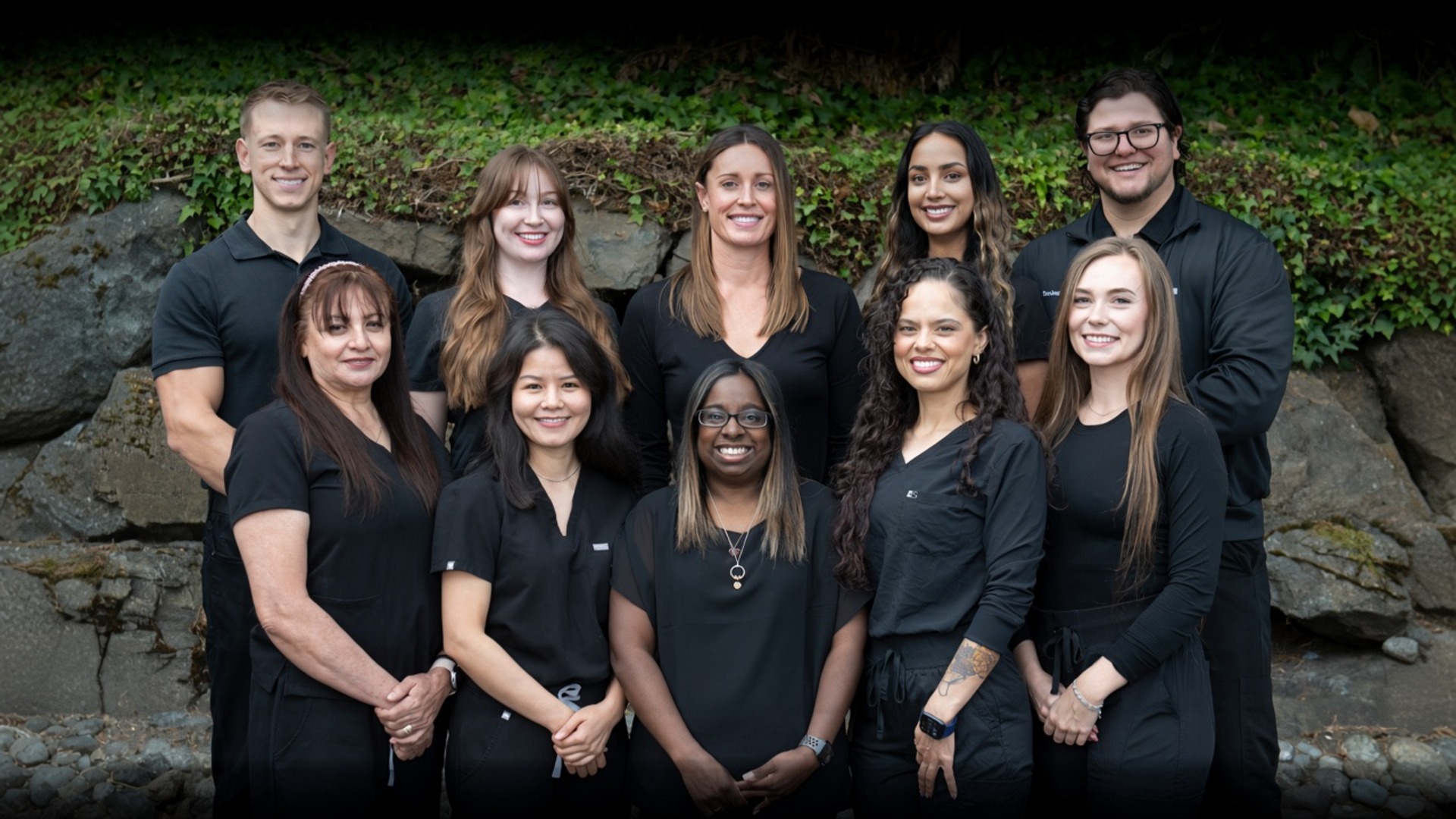 Burien dental team smiling together in front of the office building in Burien, WA