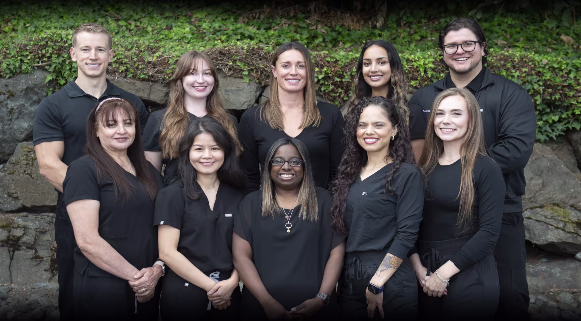 Burien dental team smiling together in front of the office building in Burien, WA