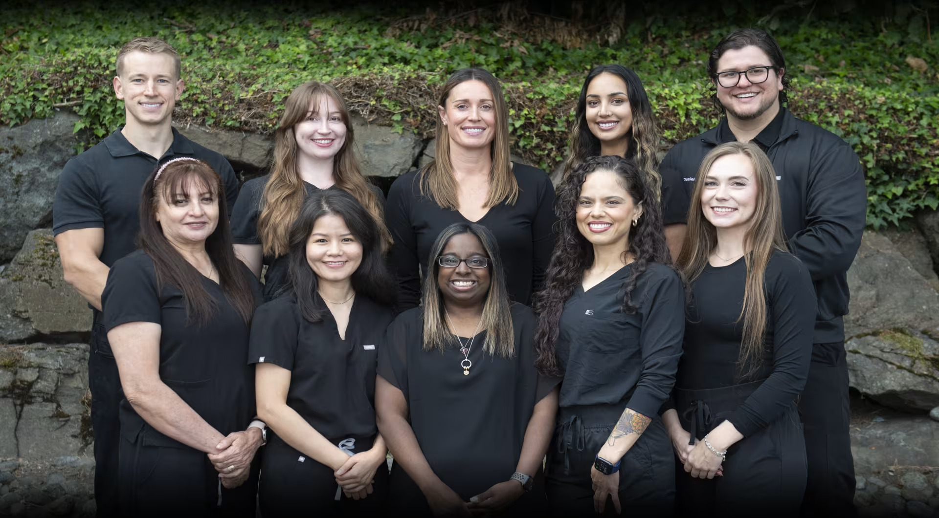 Burien dental team smiling together in front of the office building in Burien, WA
